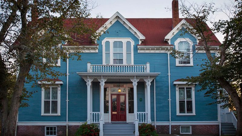 The Evergreen House, a blue Victorian house with a red roof, part of the Dartmouth Heritage Museum